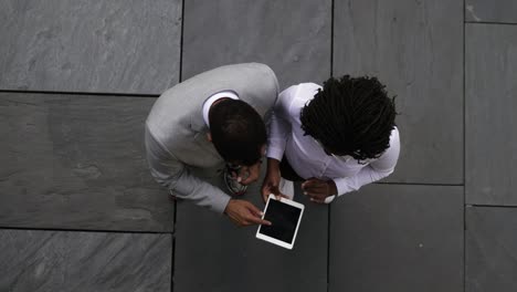 Top-view-of-two-managers-using-tablet-outdoor